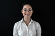 Smiling asian business woman female manager CEO student teacher in formal wear white shirt standing against black background looking at camera. Waist up view.