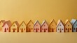 Paper houses on empty yellow background with copy space 