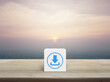 Download icon on white block cube on wooden table over modern city tower and skyscraper at sunset, vintage style, Technology internet online concept