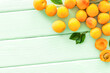 Fruit frame. Apricots and leaves on green wooden background top view space for text