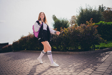 Wall Mural - Photo of pretty shiny girl wear school uniform mini skirt rucksack walking fast college outside urban city park