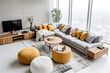 Top view of grey sofa and yellow knitted pouffes near tv unit. Minimalist interior design of modern living room, home.