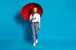 Photo portrait of nice young lady walking hold umbrella wear trendy white garment isolated on blue color background