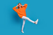 Photo of adorable positive woman wear trendy orange clothes dance look empty space isolated on blue color background