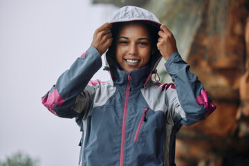 Woman, outdoor or portrait for hiking in rain with fashion, freedom and exercise for wellness. Female person, nature or smile on mountain for adventure with jacket, clothes for active lifestyle