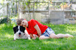 Active kid boy playing with family dog in garden. Laughing school child having fun with training dog, running and playing with ball. Happy family outdoors. Friendship between animal and kids