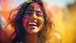 Young Indian woman joyfully laughing with Holi colors