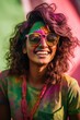 Joyful woman in sunglasses celebrates Holi with face covered in color