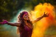 Joyous woman with arms open amidst Holi color celebration