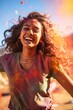 Joyful woman with Holi colors exploding in sunlight