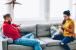 Young family sitting on sofa in living room using smartphone ignore real conversation  blogging and chatting in social networks, male and female hipsters addicted to modern gadgets and internet