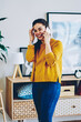 Cheerful brunette woman laughing during mobile phone conversation with friend having cheap tariffs for calls, happy hipster girl having fun satisfied with talking on telephone on leisure at home
