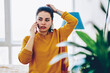 Serious young woman having mobile phone consultancy with customer support operator standing at home, pensive hipster girl making telephone call for checking banking balance recalling information