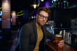Pensive of relaxed businessman with glass of foamy beer in bar