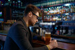 Pensive of relaxed businessman with glass of foamy beer in bar