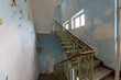 Stairs with metallic rail in abandoned building. Stairway inside an old house.