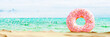 Pink melting donut on beautiful sand beach in front of turquoise blue sea. Summer concept background. 3D Rendering, 3D IllustratioN