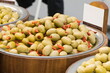 Fresh olives in barrels on street market or in grocery shop. Snack containing vitamins
