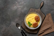 Mashed potatoes with cutlet in a bowl on a wooden board, dark rustic background. Top view, flat lay
