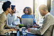 © peopleimages.com - Business woman, laptop and coaching with team in meeting, presentation or conference at office. Female person talking to group of employees in finance for company strategy, growth or revenue at desk