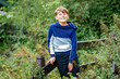 Portrait of positive preteen school kid boy in nature park. Happy child looking at the camera. Schoolboy smiling.