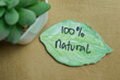 Concept of 100 % Natural write on sticky notes isolated on Wooden Table.