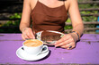 A girl with a cup of cappuccino with coconut milk and a chocolate raw food, vegetarian cake.