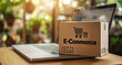 © PrettyStock - Online Shopping Cardbox with E-Commerce Text with Open Laptop displaying shopping e-commerce shop for online sales or advertising.