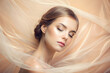 beautiful young woman in peach color silk veil. Sensual Girl with make-up