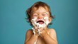  A young child eagerly eats a slice of cake, icing smeared on his face and mouth agape