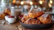 A plate of croissants on a wooden table.