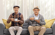 Elderly men sitting on a sofa and having a cup of tea