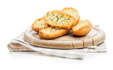 Fototapeta Lawenda - Garlic crisp bread Slices Topped With Herbs on cutting board isolated on white background.