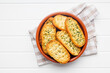 Garlic crisp bread Slices Topped With Herbs in bowl. Top view.