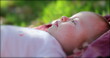 © Marco - Dreamy newborn baby infant lying in grass in outdoors