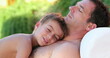 © Marco - Father and son together small boy laid on dad chest outside