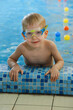 © ninelutsk - Happy cute toddler child near the pool side smiling in goggles after swimming lesson indoor. Physical development and healthy water activities for kids