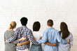 © Prostock-studio - A group of multiethnic teenagers stands close together with their backs to the viewer, arms around each other in a display of friendship and unity, back view