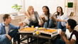 © Prostock-studio - A diverse group of multiethnic friends are gathered around a wooden table. They are enjoying slices of hot pizza, engaged in casual conversation and laughter.