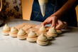 Professional makes the macaron filling with light brown cream