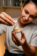Chef in a white T-shirt top makes delicate macaron in her hands