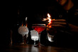 Bartender lighting a fire on the side of a cocktail glass in a cocktail glass on a tall stem