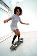 Happy afro american girl with skateboard. Real people lifestyle.