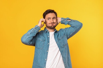 Aufkleber - Puzzled man wearing a blue shirt is engaged in a phone conversation, holding a cell phone to his ear. He appears focused and attentive, possibly discussing important matters.