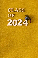 Wall Mural - Class of 2024 text with graduated cap on golden glitter background. Graduation holiday concept.