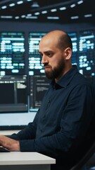Poster - vertical video man programming in high tech facility with server rows providing computing resources 
