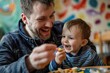 © Jorge Ferreiro - Smiling father and his young son eating a snack