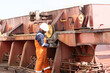 © debjit - deck crew member of ship preparing hatch coaming surface plate uning pnumatic buffing grinder