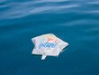 Deflated star-shaped graduation balloon floating on calm blue Lake Michigan water