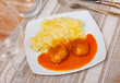 on square plate,portion of a hearty lunch - creamy mashed potatoes with round minced chicken meatballs with tomato sauce